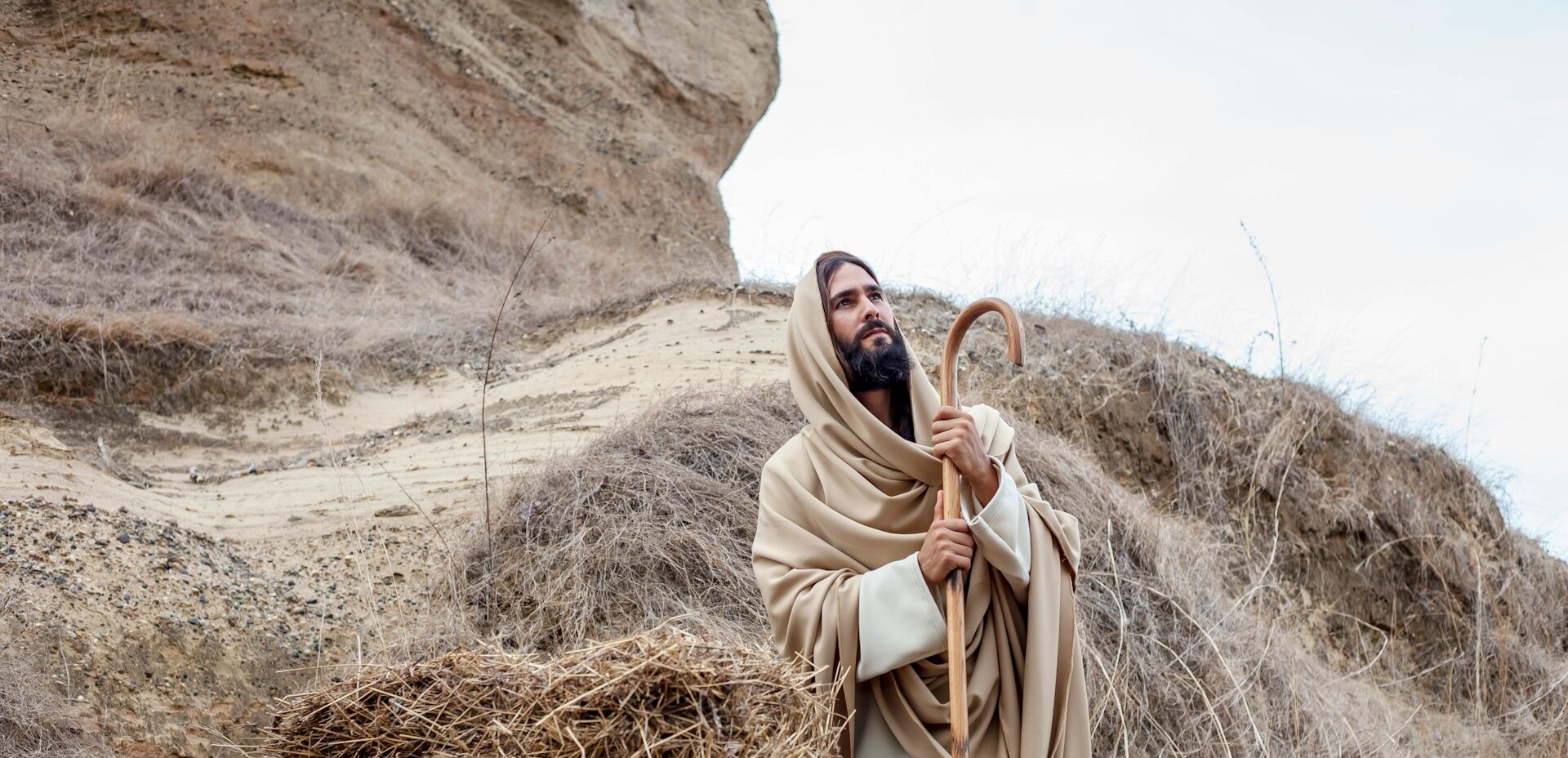 Jesus Christus steht draußen auf einen Stab gestützt